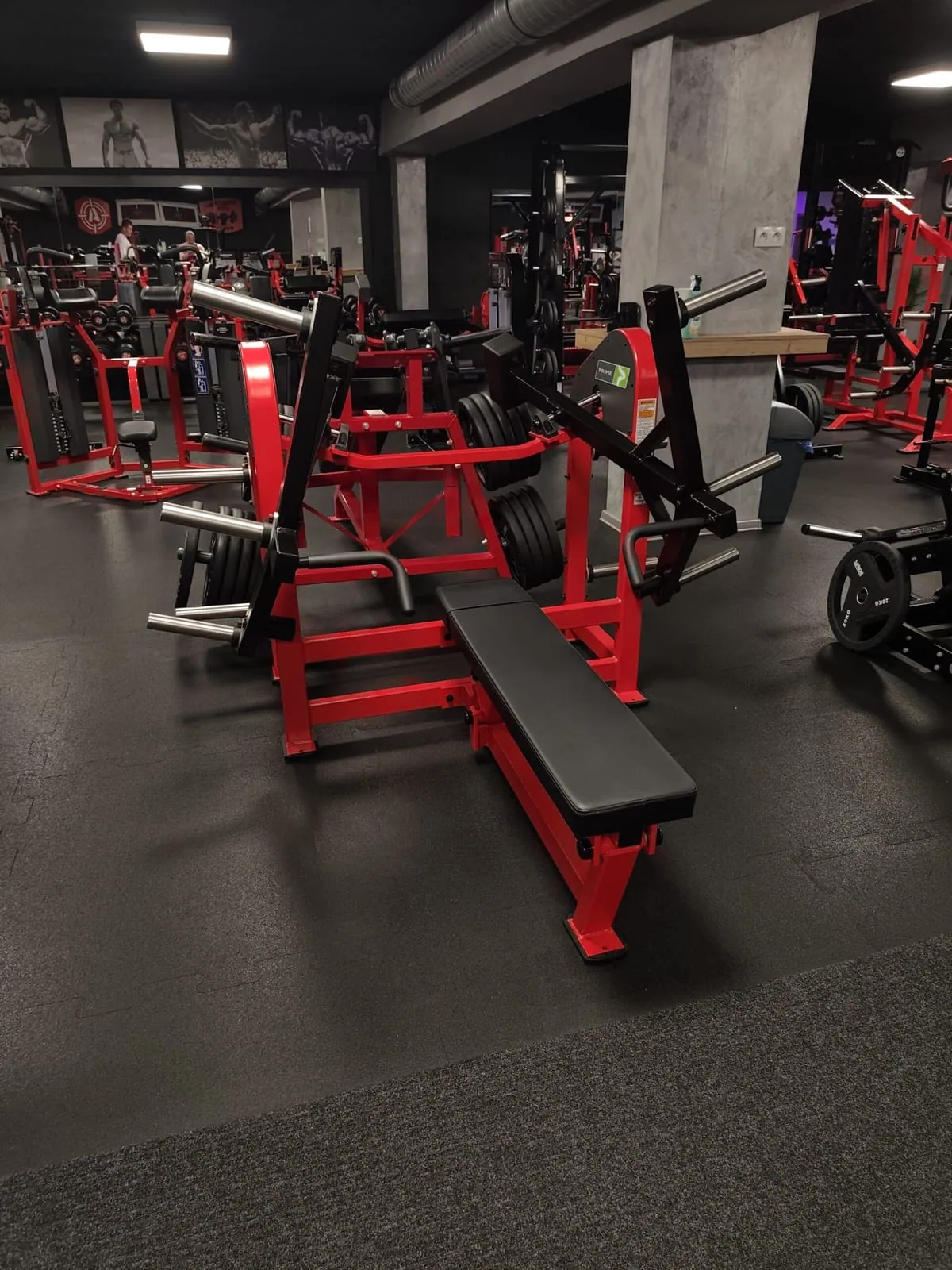 Červené stroje Hammer Strength s lavicou